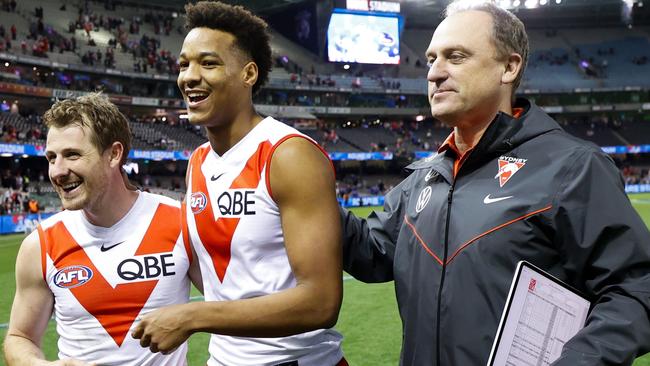 Happy Swans Harry Cunningham, Joel Amartey and coach John Longmire celebrate their win. Picture: AFL Photos/Getty Images