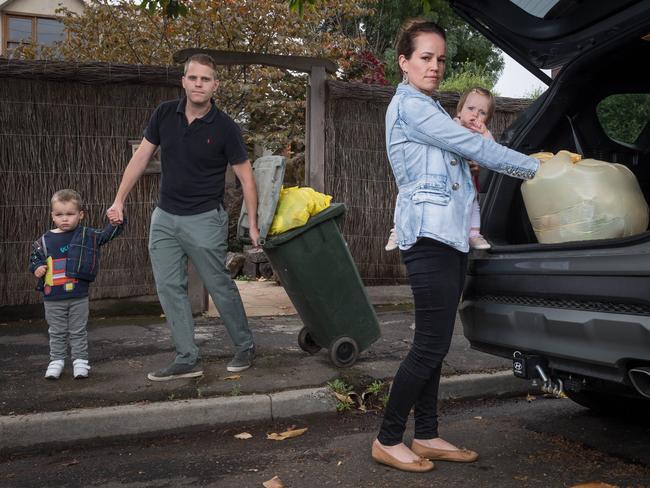 Hobsons Bay Council will resume weekly rubbish collection after a push to block the resumption failed at an urgent meeting. Parents Mark and Davina Geels hold onto their children Hamish, 3 and Imogen, 1, as they load excess rubbish into their car. Picture: Jake Nowakowski