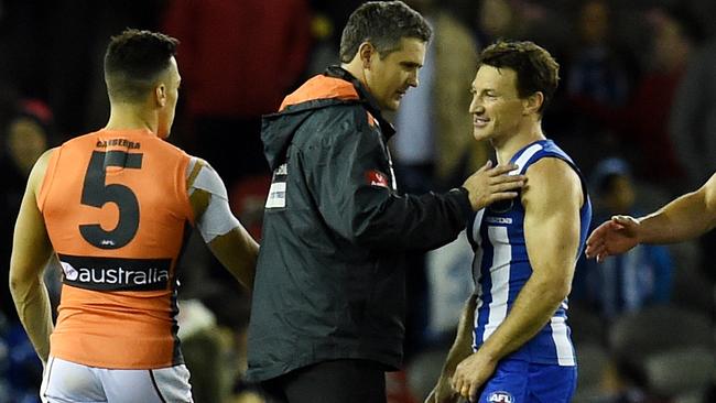 GWS coach Leon Cameron consoles North Melbourne champ Brent Harvey.