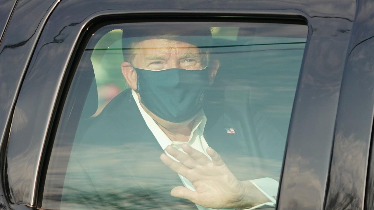 US President Trump waves from the back of a car in a motorcade outside of Walter Reed Medical Center in Bethesda, Maryland on October 4, 2020. Picture: ALEX EDELMAN / AFP.