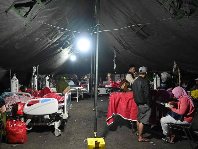 Wounded people rest under a tent outside a hospital in Cianjur. Picture: AFP.