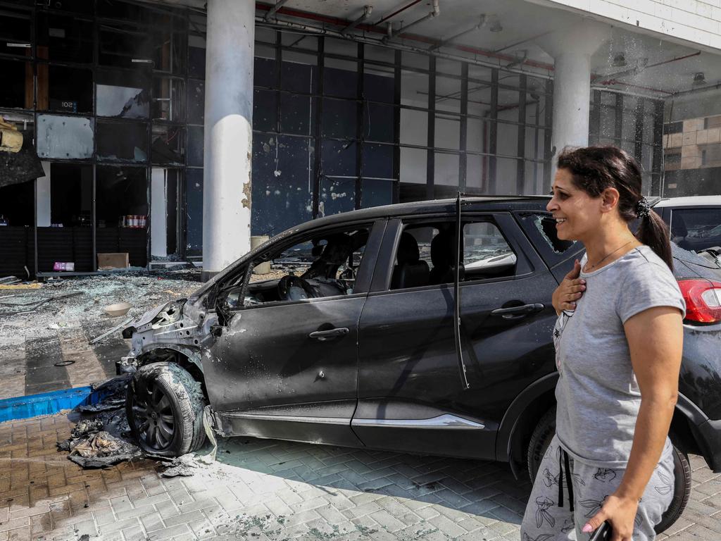 A woman reacts in front of a supermarket after it was hit by an incoming rocket in the southern Israeli city of Ashkelon. Picture: AFP