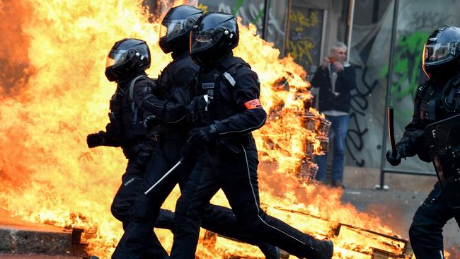 French riot police run past a fire during a demonstration in Paris on March 23, 2023, over controversial pension reforms. Picture: Alain Jocard/AFP