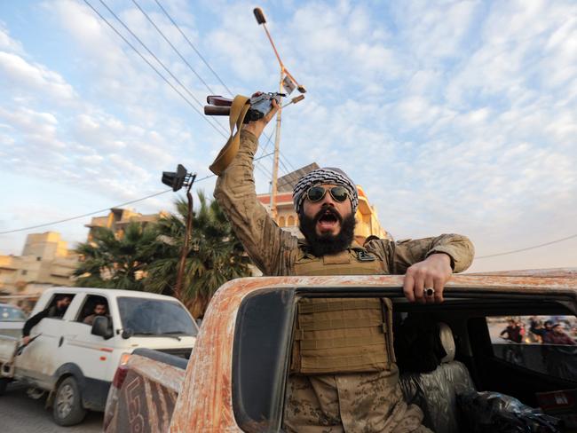 A Syrian anti-government fighter cheers as he enters the west-central city of Hama. Picture: AFP