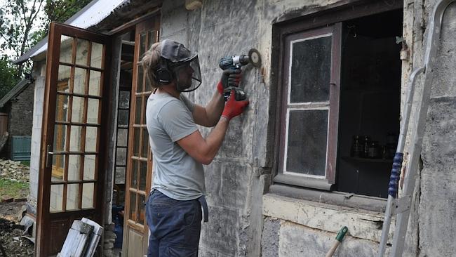 Owen cleaning the surface of the toolshed in preparation for rendering.