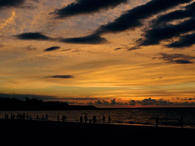 The sun sets as the hoards watch on during the last Mindil Markets for 2017. Picture: Michael Franchi