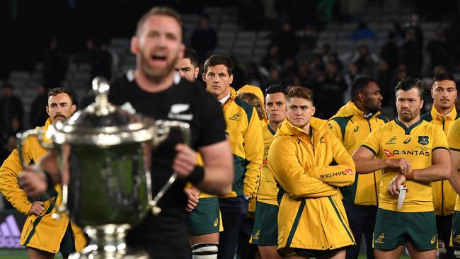 Wallabies players look on as NZ captain Kieran Read holds the Bledisloe Cup last year