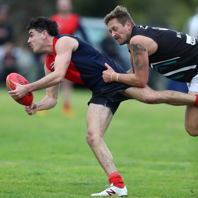 Swifts Creek’s Robbie Farnham is tackled by Omeo-Benambra’s Campbell Ahsam.