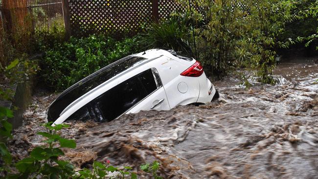 A car washed down a creek off Slape Cres at Waterfall Gully in the storm’s aftermath. Picture: Roger Wyman