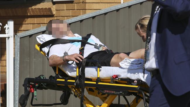 A man is treated by ambulance officers after the arrest. Picture: Justin Lloyd