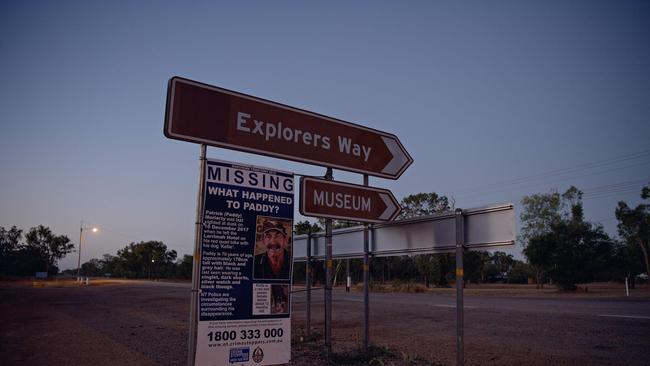 The Stuart Highway at sunrise in the township of Larrimah, featuring a missing persons sign for Paddy Moriarty.