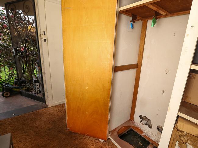 A leaking pipe can be seen through a hole in the floor in the hallway cupboard. Picture: Ian Currie