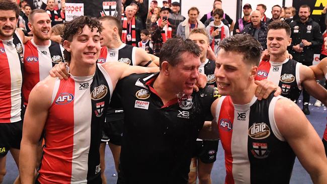 Nick Coffield, interim St Kilda coach Brett Ratten and debutant Doulton Langlands are showered during the club song after their win over Western Bulldogs. Picture: AAP Image/Julian Smith.