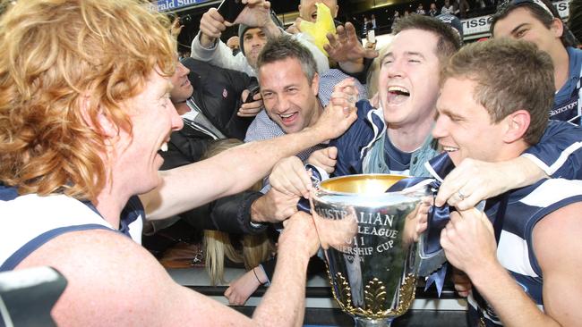 Cameron Ling and Joel Selwood get into premiership celebrations.