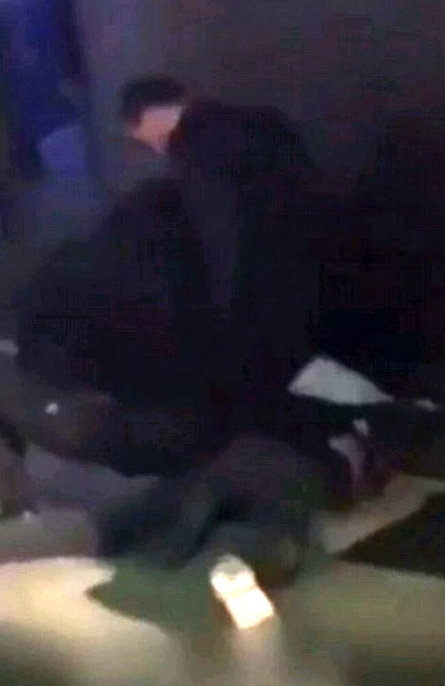 Noll thrown to the ground by security guards outside the strip club.