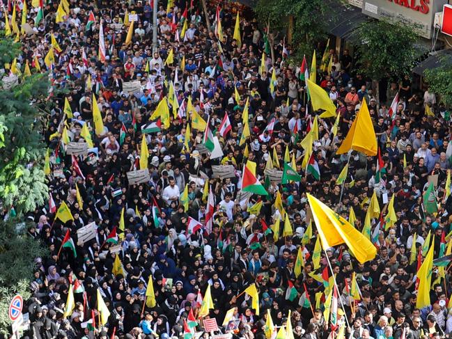 People take part in a demonstration organised by Lebanese Shiite group Hezbollah in the southern suburbs of Beirut on October 18, 2023, following a strike which ripped through a Gaza hospital compound killing hundreds the day before. Thousands rallied across the Arab world on October 18 to protest the deaths of hundreds of people in a strike on a Gaza hospital they blame on Israel, despite its denials. (Photo by ANWAR AMRO / AFP)