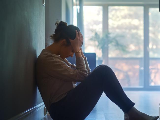 istock generic:  woman, abuse, DV, domestic violence, harassment, sexual harassment.   Sad Young Woman Sitting on the Floor In the Hallway of Her Appartment, Covering Face with Hands. Atmosphere of Depression, Trouble in Relationship, Death in the Family. Dramatic Bad News Moment . Picture: istock