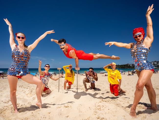 Cirque du Soleil performers Morgane, Li, Ugo, Melvin and Vanessa pose up on Bondi Beach with lifesavers Neve Davey and Cooper Falzon. Picture: Tom Parrish