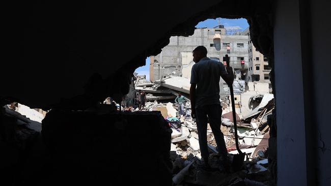 A Palestinian stands among damaged buildings at the Nuseirat refugee camp in the central Gaza Strip. Picture: AFP