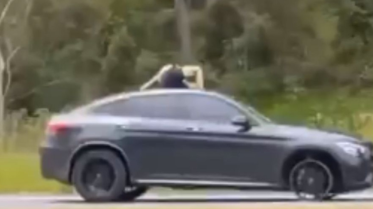 A man stands in the sunroof of the car during the chase. Picture: Josh Stocky/Instagram