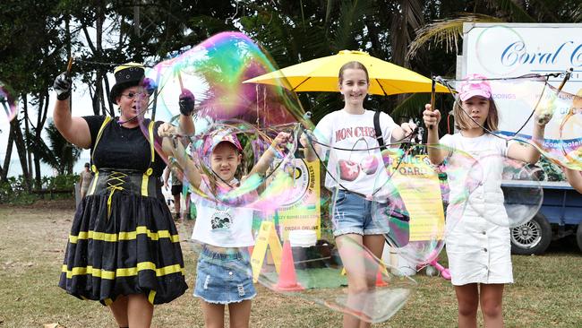 Bugzy Bumblebee, Suri Sergeant, 7, Charlize Clarke, 12, and Hannah Sergeant, 12, play with giant bubbles at Port Douglas Carnivale's family beach day, held on Four Mile Beach and the Port Douglas Surf Lifesaving Club. Picture: Brendan Radke