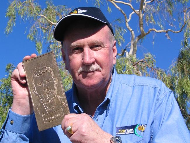 In one of the last photos taken of the Tree of Knowledge before it was poisoned in 2006, the then AWU national president Bill Ludwig holds one of 13 bronze tiles created on the Fraser Coast and presented to the Tree of Knowledge Committee in Barcaldine the same month.