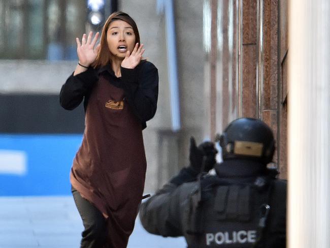 Elly Chen runs towards a police officer after escaping the cafe. Picture: Adam Taylor