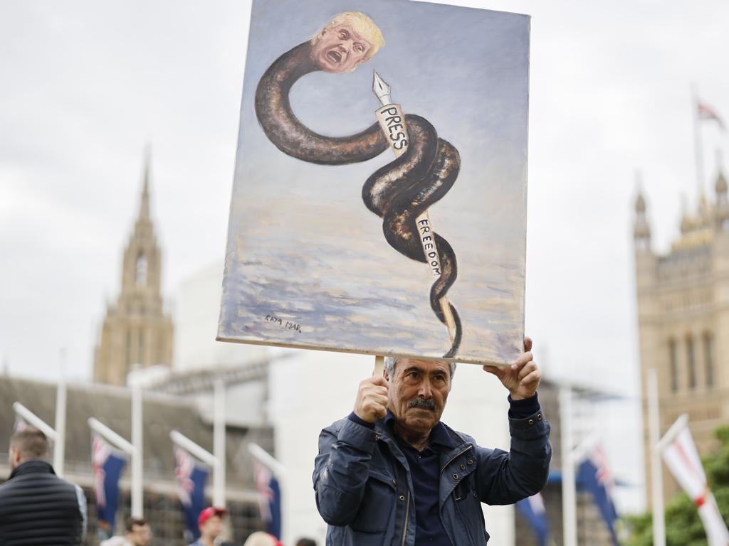 Political artist Kaya Mar holds up a work depicting US President Donald Trump outside the Houses of Parliament where demonstrators are gathering for a massive anti-Trump demonstration on Tuesday. Picture: Tolga Akmen / AFP