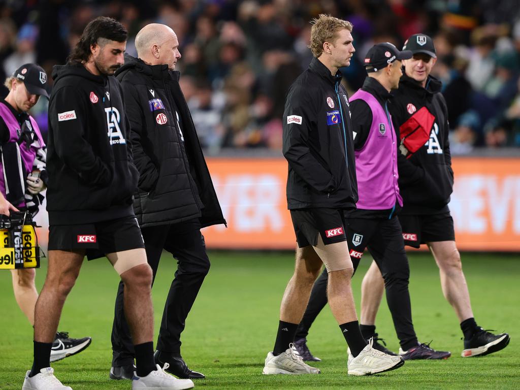 Ken Hinkley and his injured guns Jason Horne-Francis and Lachie Jones walk off Adelaide Oval. Picture: Sarah Reed/AFL Photos