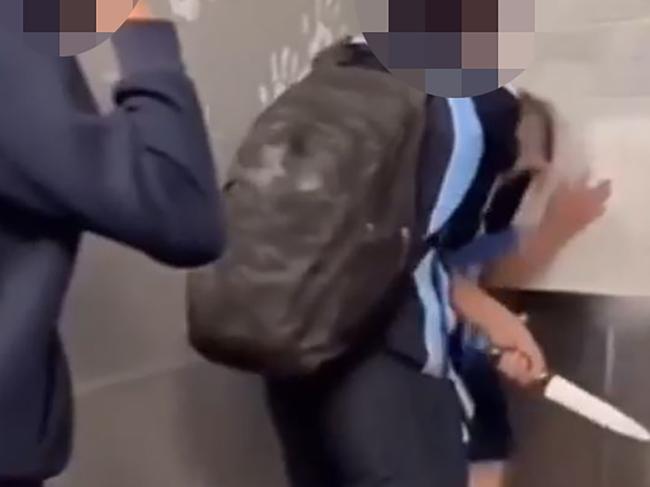 Screen grabs of a brawl in a boys bathroom at Chifley College in Sydney's west where three boys bash another boy who is cowering in the corner. One of the bullies pulls out a large kitchen knife and threatens the boy with it.,