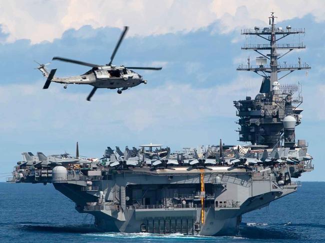 200720-N-OW019-0013 INDIAN OCEAN (July 20, 2020) An MH-60S Sea Hawk helicopter, with the ìScreamin' Indians" of Helicopter Sea Combat Squadron (HSC) 6, flies above the aircraft carrier USS Nimitz (CVN 68) in the Indian Ocean. The Nimitz Carrier Strike Group, consisting of flagship Nimitz, the Ticonderoga-class guided-missile cruiser USS Princeton (CG 59), and the Arleigh Burke-class guided-missile destroyers USS Sterett (DDG 104) and USS Ralph Johnson (DDG 114), along with the Indian Navy ships Rana, Sahyadri, Shivalik and Kamorta, are currently participating in a cooperative deployment Indian Ocean. (U.S. Navy photo by Mass Communication Specialist 2nd Class Logan C. Kellums/Released)