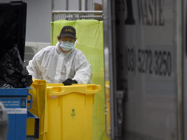 A worker in full PPE removes bags of clinical waste from Arcare Maidstone Aged Care after a case emerged at the facility. Picture: NCA NewsWire / Andrew Henshaw