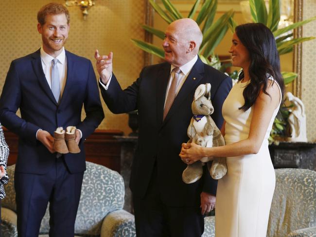 Governor-General Peter Cosgrove gives the Duke and Duchess of Sussex their first baby gift — a toy kangaroo and tiny Ugg boots. Picture: AP