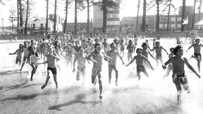 Royal Far West kids, with the centre in the background, entering the surf at Manly in February, 1977. Picture: Manly Daily