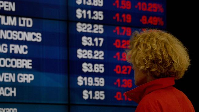 A visitor to the Australian Securities Exchange (ASX) looks at share prices on a big screen in Sydney on October 11, 2018. - The Australian share market joined the regional bloodbath after the sell off on Wall Street, plunging to a more than five-month low as all sectors dropped into the red. (Photo by PETER PARKS / AFP)