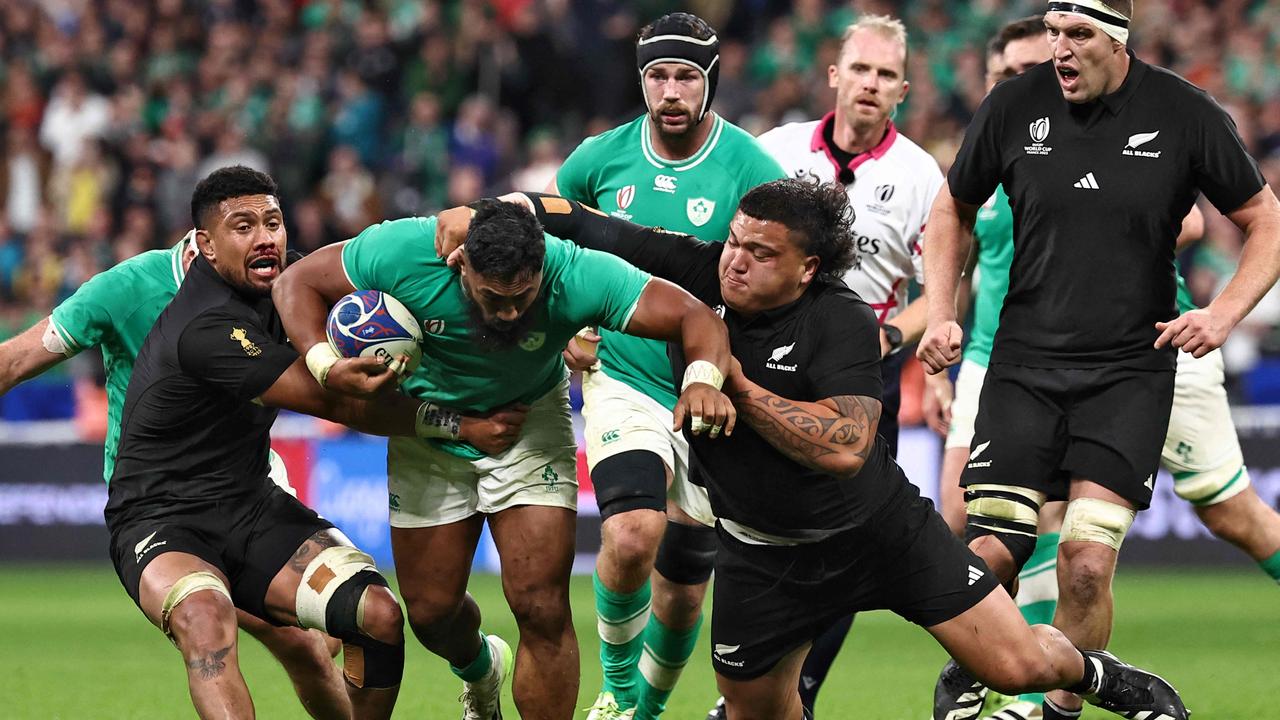 Ireland's inside centre Bundee Aki (L) is tackled by New Zealand's number eight Ardie Savea (L) and New Zealand's prop Tamaiti Williams (R) during the France 2023 Rugby World Cup quarter-final match between Ireland and New Zealand at the Stade de France in Saint-Denis, on the outskirts of Paris, on October 14, 2023. (Photo by Anne-Christine POUJOULAT / AFP)