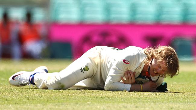 Will Pucovski of Australia dives for the ball and injures his shoulder