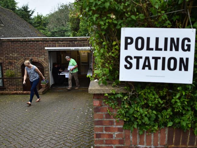 People leave after casting their ballot papers in a polling station set up inside the garage of a residential home in Croydon, south of London on June 23, 2016, as Britain holds a referendum to vote on whether to remain in, or to leave the European Union (EU). Millions of Britons began voting Thursday in a bitterly-fought, knife-edge referendum that could tear up the island nation's EU membership and spark the greatest emergency of the bloc's 60-year history. / AFP PHOTO / BEN STANSALL