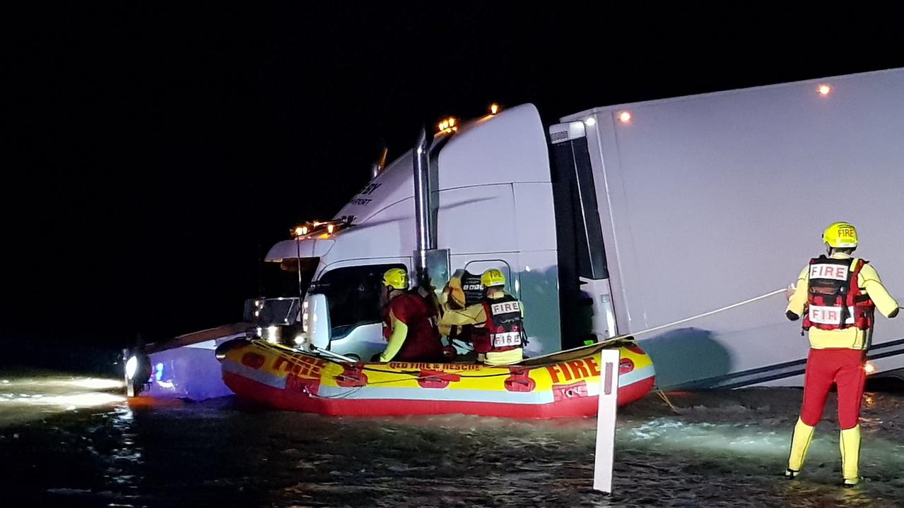 A truck driver was rescued from floodwaters by emergency crews after rolling on a Goondiwindi highway. Picture QFES Media