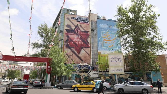 Iranians walk next to an anti-Israel poster in Tehran on April 13. Picture: AFP