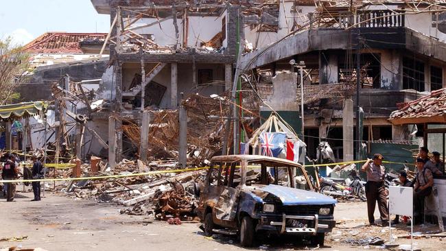 Forensic police officers and the wreckage of car at the scene of the Sari Club nightclub blast in Kuta.