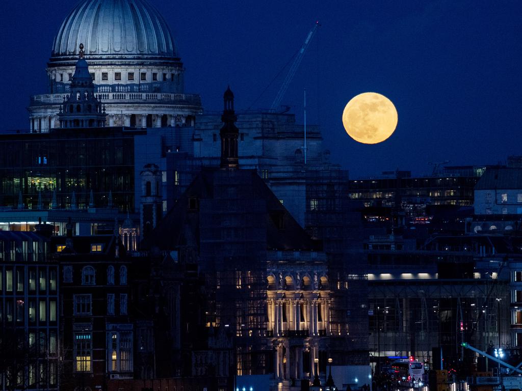 A supermoon rises behind St. Paul’s Cathedral and skycrapers on January 31, 2018 in London, United Kingdom. The super blue blood moon is a rare combination of a supermoon, a blood moon and a blue moon all simultaneously occuring. Picture: Chris J Ratcliffe/Getty