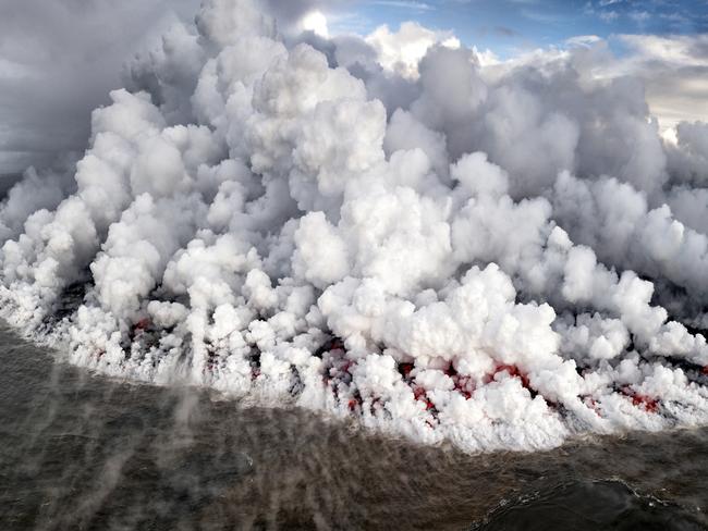 Recently the Kilauea volcano erupted causing thousands of gallons of lava to flow into the ocean. Picture: Leighton Lum / National Geographic Photo Contest