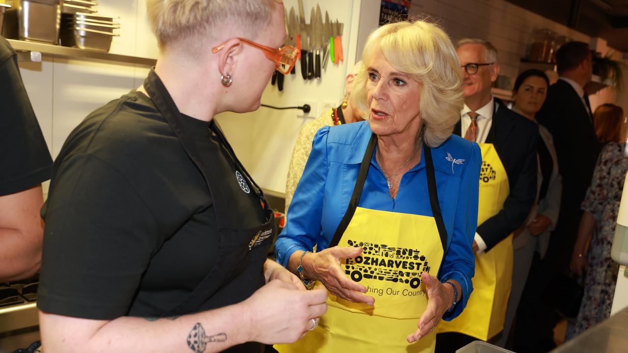 Queen Camilla assists with meal preparation during the visit. Picture: Vogler-Pool/Getty Images