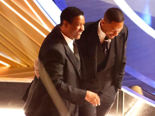 Denzel Washington puts his arm around Will Smith after the star’s outburst. Picture: Getty Images