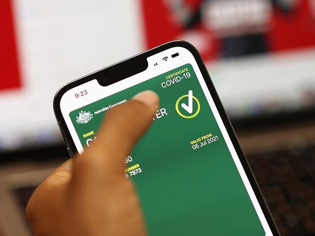 SYDNEY, AUSTRALIA - OCTOBER 14: In this photo illustration a woman holds a phone displaying a valid Australian digital COVID-19 certificate on October 14, 2021 in Sydney, Australia. Australians are downloading digital COVID-19 vaccine certificates to prove their vaccination status as restrictions ease for people who are fully vaccinated against the coronavirus. (Photo illustration by Cameron Spencer/Getty Images)