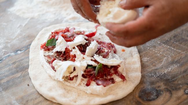 The pizza fritta involves toppings like prosciutto and mozzarella.