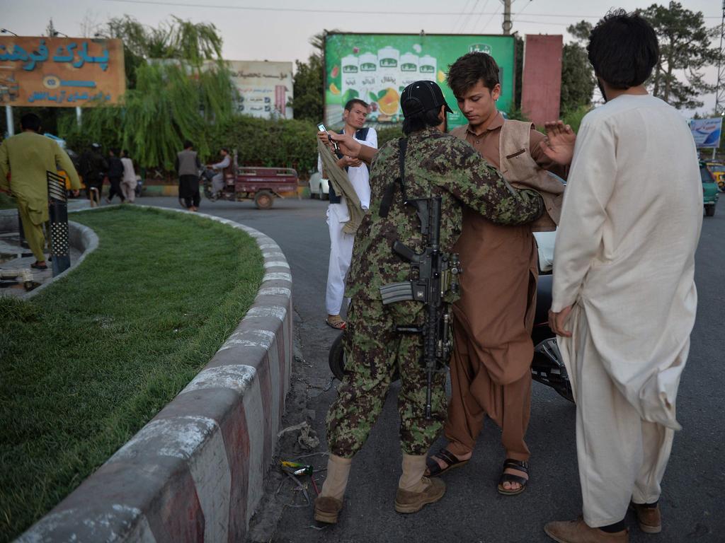 A young boy is searched by a Taliban fighter in Herat. Picture: Hoshang Hashimi/AFP