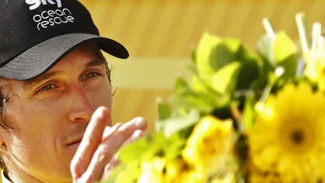 Britain's Geraint Thomas, wearing the overall leader's yellow jersey, throws his flowers to his wife Sarah Elen on the podium after the 20th stage of the Tour de France. Picture: AP Photo/Peter Dejong