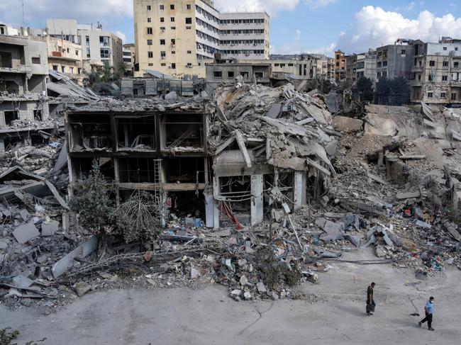 People walk past the remains of buildings destroyed in Israeli airstrikes in Nabatieh, Lebanon. Picture: Getty Images